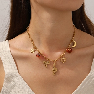 Gold vintage necklace with musical note star and moon pendants on a fashion model