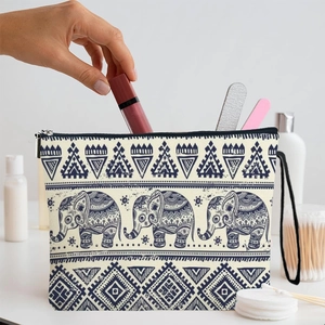 Grand sac cosmétique en toile avec motif éléphant et sangle sur une coiffeuse blanche