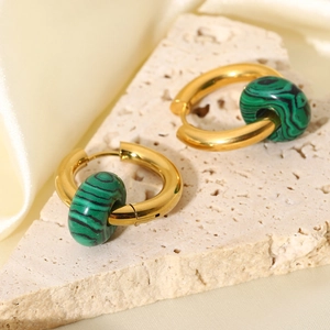 Macro shot of 18K gold plated earrings with cylindrical green malachite texture stones
