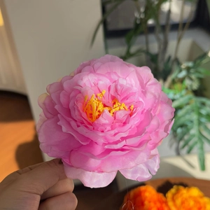 Detailed close-up of pink peony hair clip featuring realistic silk petals and yellow stamen