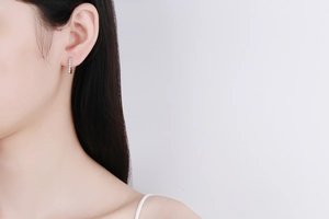 Close-up of minimalist sterling silver earring with single row of cubic zirconia stones
