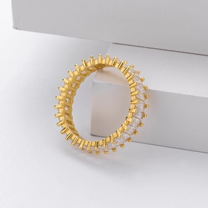 Close-up of gold eternity ring with clear cubic zirconia pavé stones on grey block