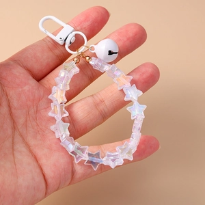 Detailed shot of star beads keychain with white bell and iridescent acrylic charms