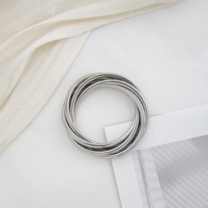 Minimalist silver multi-layer spiral spring bracelet with a metallic industrial design