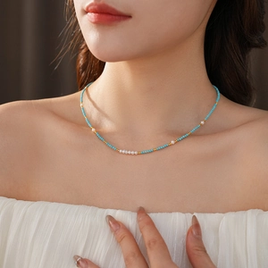 Close-up of model wearing titanium necklace with blue turquoise and freshwater pearls