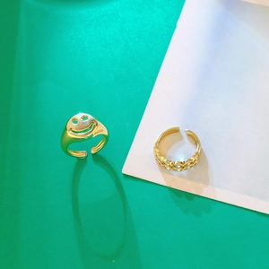 Set di due anelli dorati regolabili con faccina sorridente e design a doppio strato intrecciato