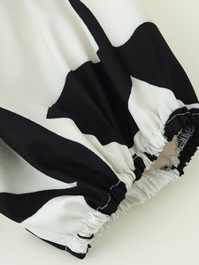 Detailed close-up showing the elastic cuffs and black and white abstract print on the dress