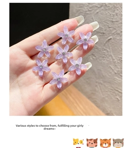 Détail de mini pinces à cheveux fleurs violettes en résine pailletée avec strass au centre