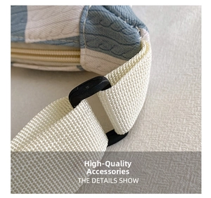 Detailed macro view of the blue plaid knit fabric and durable strap adjuster on bag