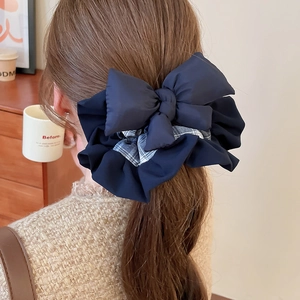 Detail of navy blue bow hair scrunchie with grid pattern shown on hair from the back