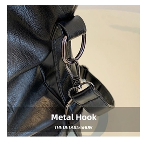 Detailed close-up of durable silver metal hook and textured black leather bag strap