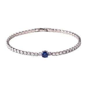 Close-up of silver tennis bracelet with circular cubic zirconia and a blue center stone