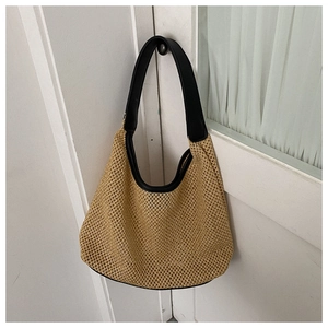 Detail showing beige woven mesh texture with contrast black leather strap on a beach bag