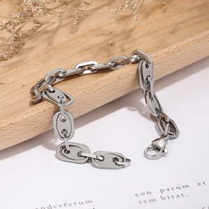 Silver stainless steel mariner link bracelet displayed on a wooden tray and white paper