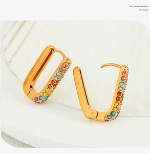 Detail of gold rectangular hoop earrings with colorful rainbow cubic zirconia stones