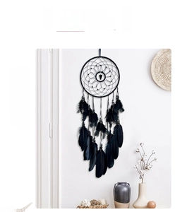 Detail of hand-woven black feather dreamcatcher with beads in an Indian style decor