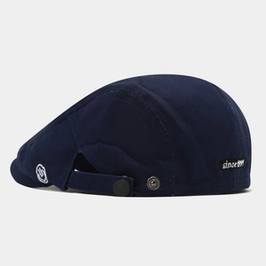 Detail of navy blue cotton beret showing the back adjustable strap and since 1991 patch