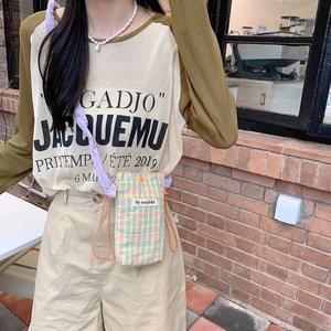 Mini checkered crossbody phone bag with yellow pattern and nylon rope strap on model