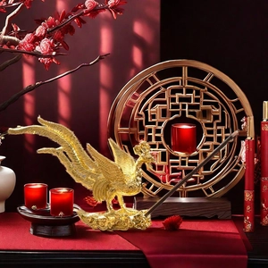 Close-up of golden phoenix incense holder with intricate cloud patterns on a red background