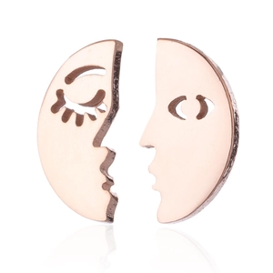 Macro shot of rose gold abstract face earrings featuring creative split circle design