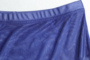 Detailed close-up of dark blue mesh fabric with precise stitching on a two-piece set