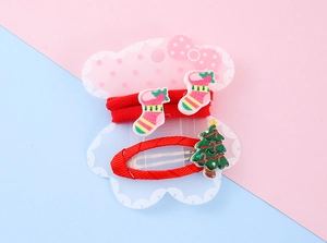 Detail of Christmas hair clips set with red stockings and a green tree for girls