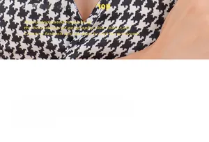 Detailed close-up of the black and white houndstooth pattern and V-neckline of the garment
