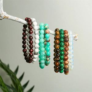Tiger eye and matte onyx beaded bracelets displayed on a minimalist white tree branch