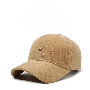 Detail of camel corduroy baseball cap showing herringbone texture and small crown logo