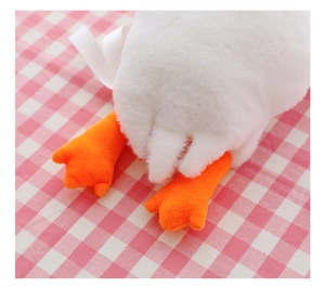 Close-up of white plush goose backpack showing soft texture and orange webbed feet
