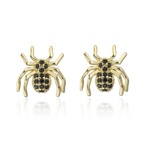 Detailed view of gold spider earrings with black zircon stones on white background