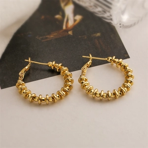 Detail of 18K gold plated hoop earrings with textured bead design and polished finish