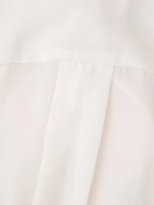 Detail of white chiffon shirt featuring a back yoke and center box pleat design