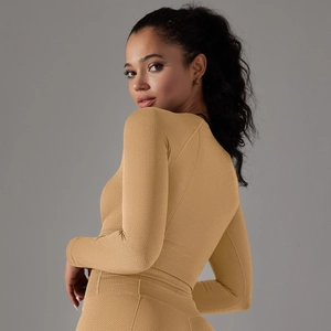 Close-up of mustard yellow long sleeve yoga top featuring textured honeycomb knit fabric