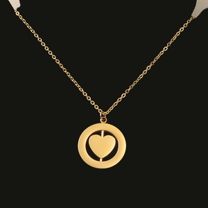 Detail of a rotating heart pendant inside a round frame on a gold stainless steel necklace