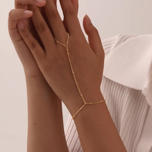 Detailed view of an 18K gold plated double layer hand chain harness with small beads
