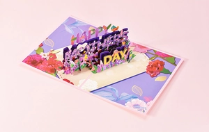 Top view of a 3D pop-up Mother's Day card with purple flowers and happy greetings