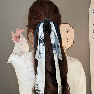 Detail of a Chinese style bow hair claw clip with ink wash ribbon on a woman's hair