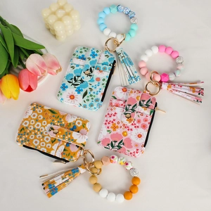 Flat lay of floral card holders with silicone bead bracelets and leather tassels