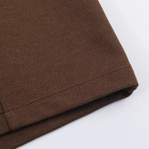 Close-up of brown textured knit fabric with professional stitching detail on romper