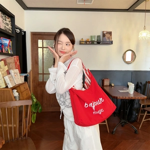 Détail du sac cabas en toile rouge avec lettrage Bonjour magic et doublure rayée chic