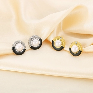 Detail of vintage French style pearl and black enamel stud earrings in gold and silver