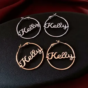 Custom Kelly name 18K gold and silver plated hoop earrings set on dark silk background