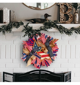 Patriotic wreath with red white blue ribbons and wooden star hanging on a fireplace