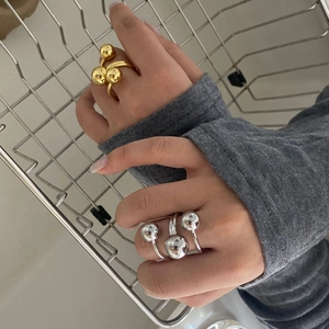 Detailed view of layered gold and silver rings with golden sphere design on model