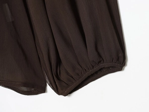 Close-up of dark brown chiffon fabric featuring detailed pleated smocking and textures