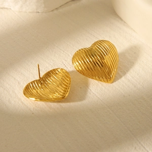 Macro shot of 18k gold plated stainless steel heart studs with vertical stripe texture