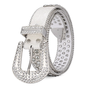Detail of white leather belt featuring silver rhinestones and a polished horseshoe buckle
