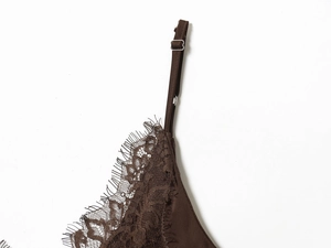 Détail de dentelle cils marron foncé et bretelle réglable sur robe en soie