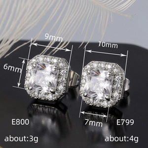 Macro view of square halo stud earrings with green zircon and sparkling accents
